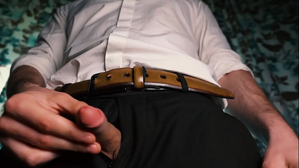 Sexy guy in a suit jerks off close-up, moans with pleasure and cums in a condom.